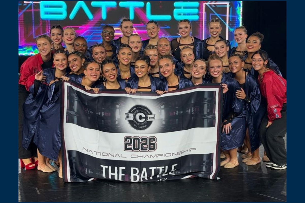large group of young women in front of national champion banner